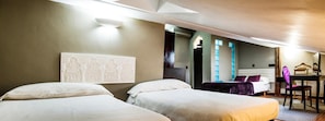 A hotel room with two beds, a desk, a chair, and a mirror.