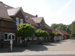 A row of brick houses with pitched roofs and small front yards. - Land Stil (Hagen im Bremischen)