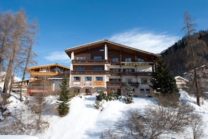 A multi-story hotel with a ski lift visible in the background.