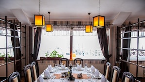 Comedor con mesa dispuesta para cuatro, ventanas amplias y faroles colgantes.