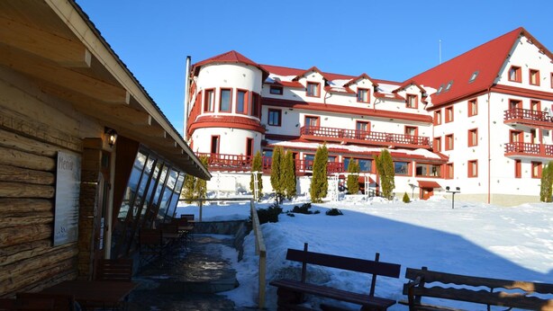 Un hotel de estilo arquitectónico tradicional, con un patio central con bancos y un camino de piedra.