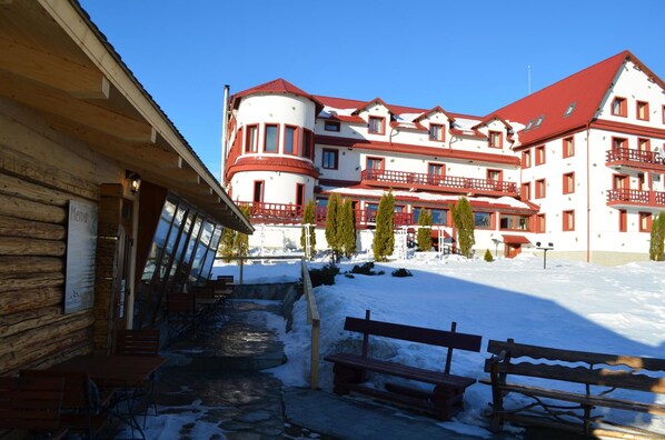 Un hotel de estilo arquitectónico tradicional, con un patio central con bancos y un camino de piedra.