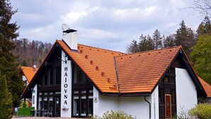 A building with a sloped roof, a satellite dish, and a sign reading 'Hajova'. - Hotel Bazant (Karlovy Vary)