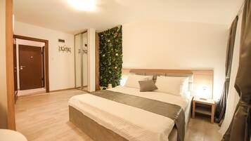 A bedroom with a large bed, a nightstand, a wall-mounted plant, and a door labeled 'Home'.
