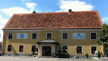 A two-story building with a red-tiled roof and a yellow facade.