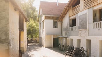 A narrow alleyway between buildings with a bicycle rack and a table with chairs.