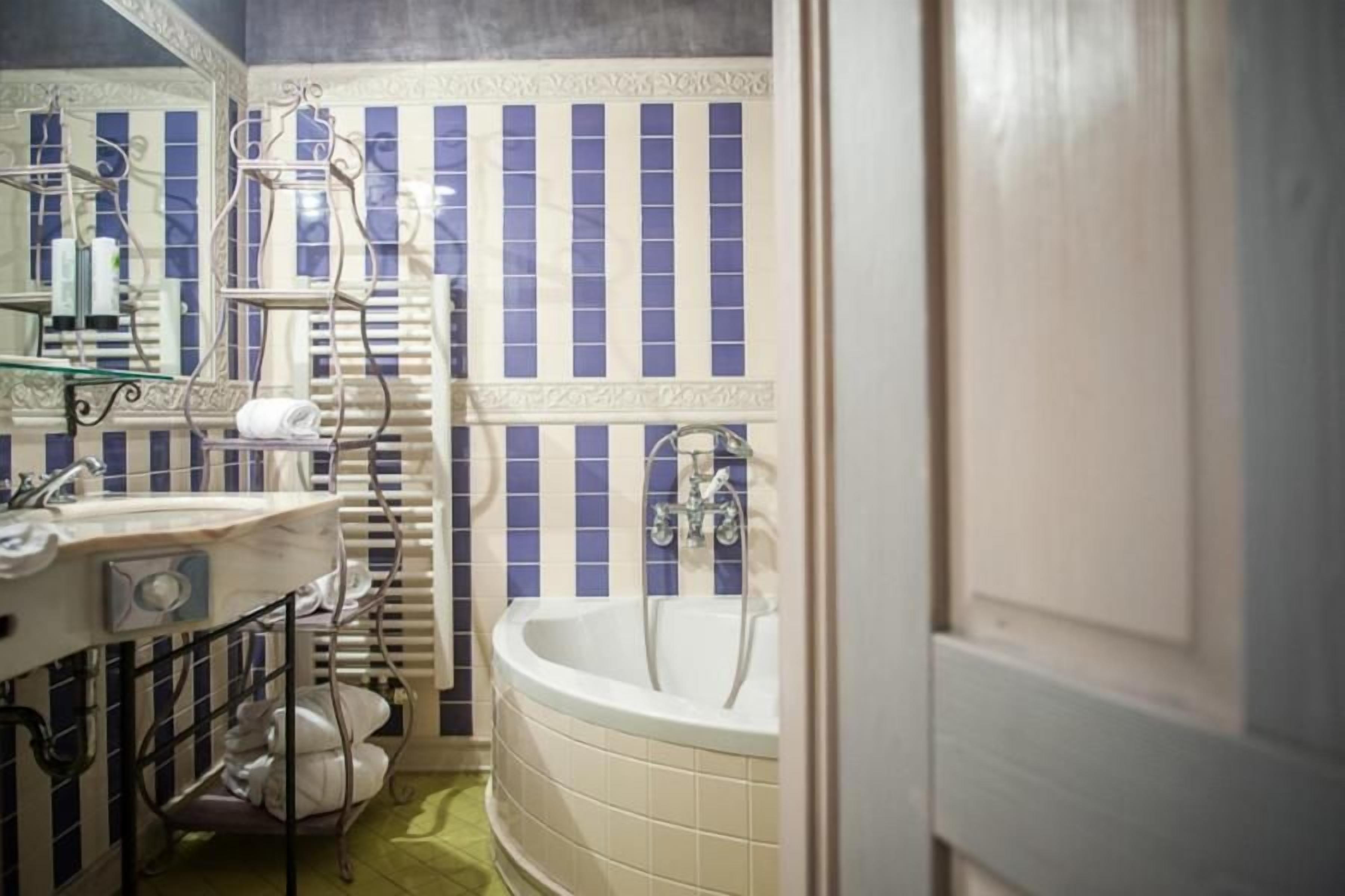 Een badkamer met een bad, een wastafel en een handdoekhouder.