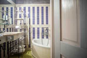 Een badkamer met een bad, een wastafel en een handdoekhouder.