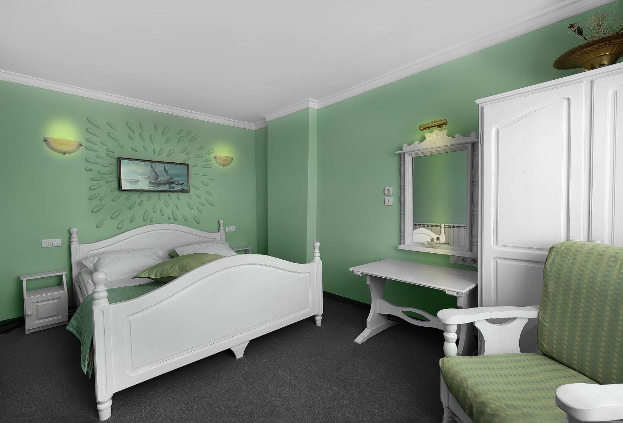 Ein Schlafzimmer mit Bett, Schreibtisch, Stuhl und Kommode.