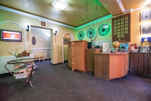 A reception area with a wooden desk, a globe, and a clock on the wall.