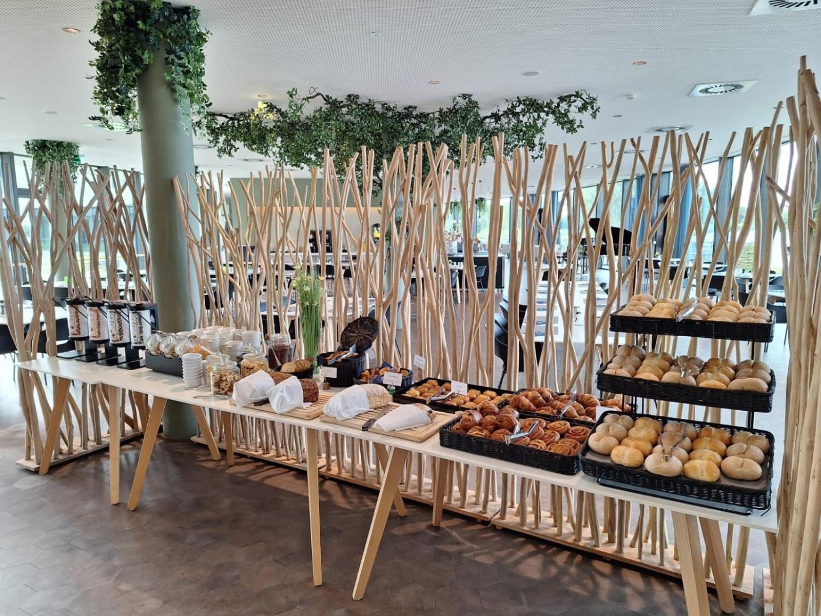 A buffet setup with various food items and a decorative wooden structure.