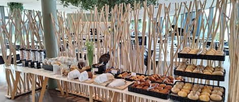 Montaje de bufé con diversos alimentos y una estructura de madera decorativa.