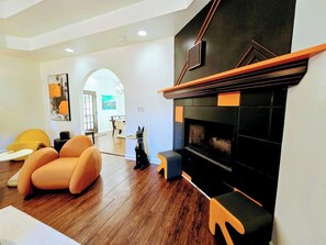 A modern living room with a fireplace, wooden flooring, and contemporary furniture. - Casa del Verde - a DZ Collection (Foley)