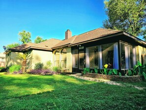 A house with a covered porch, a brick chimney, and a well-maintained lawn. - Casa del Verde - a DZ Collection (Foley)