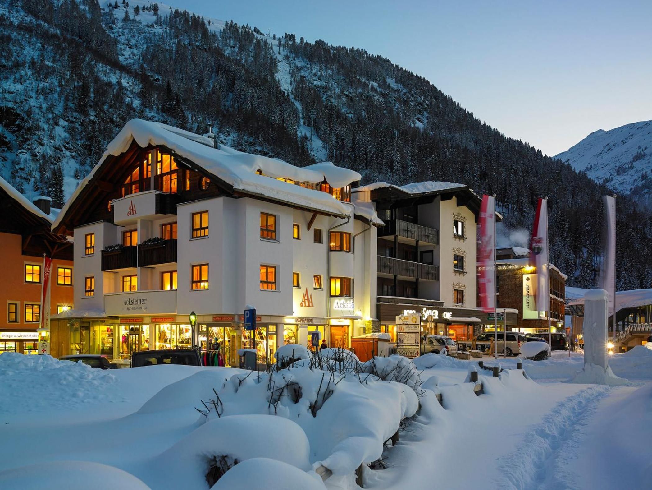 Ein Hotel mit mehreren Gebäuden, verschneiter Umgebung und einer Bergkulisse.