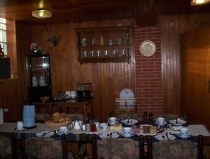 A dining area with a table set for four, surrounded by floral-patterned chairs. - Pension Im Rehwinkel (Soltau)