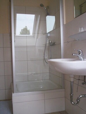 A bathroom with a shower, a sink, and a mirror. - Pension Im Rehwinkel (Soltau)