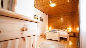 Un interno in legno con un letto, comodini e una cassettiera.