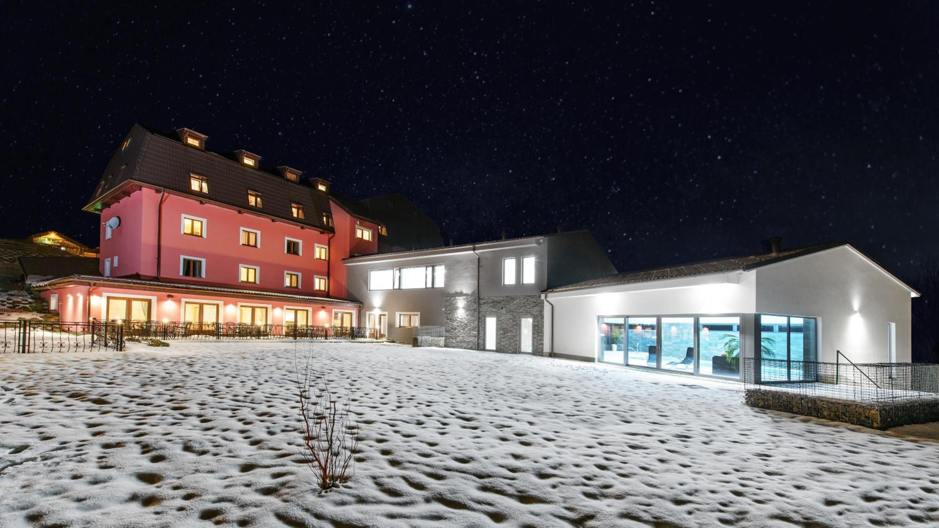 A hotel with multiple buildings, including a red and a white structure, with a snow-covered ground.