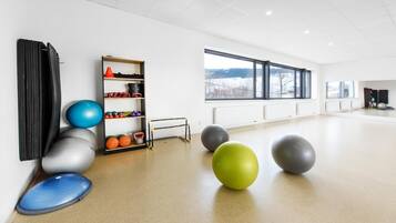 A spacious room with exercise equipment, a window with a view, and a radiator.