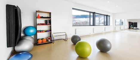 Quarto espaçoso com equipamentos de ginástica, janela com vista e radiador.