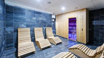 A sauna area with wooden loungers and a wooden wall.