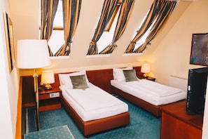 A hotel room with two beds, a desk, a chair, a television, and curtains. - Paul S Hotel (Knittelfeld)
