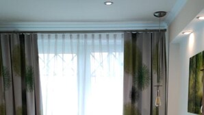 Ein Hotelzimmer mit Bett, Nachttisch, Lampe und einem Gemälde an der Wand.