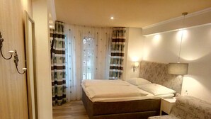 Ein Schlafzimmer mit einem Bett, einem Nachttisch, einem Sessel und einer Wandlampe.
