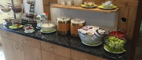 Una mesa de buffet con diversos alimentos y recipientes.