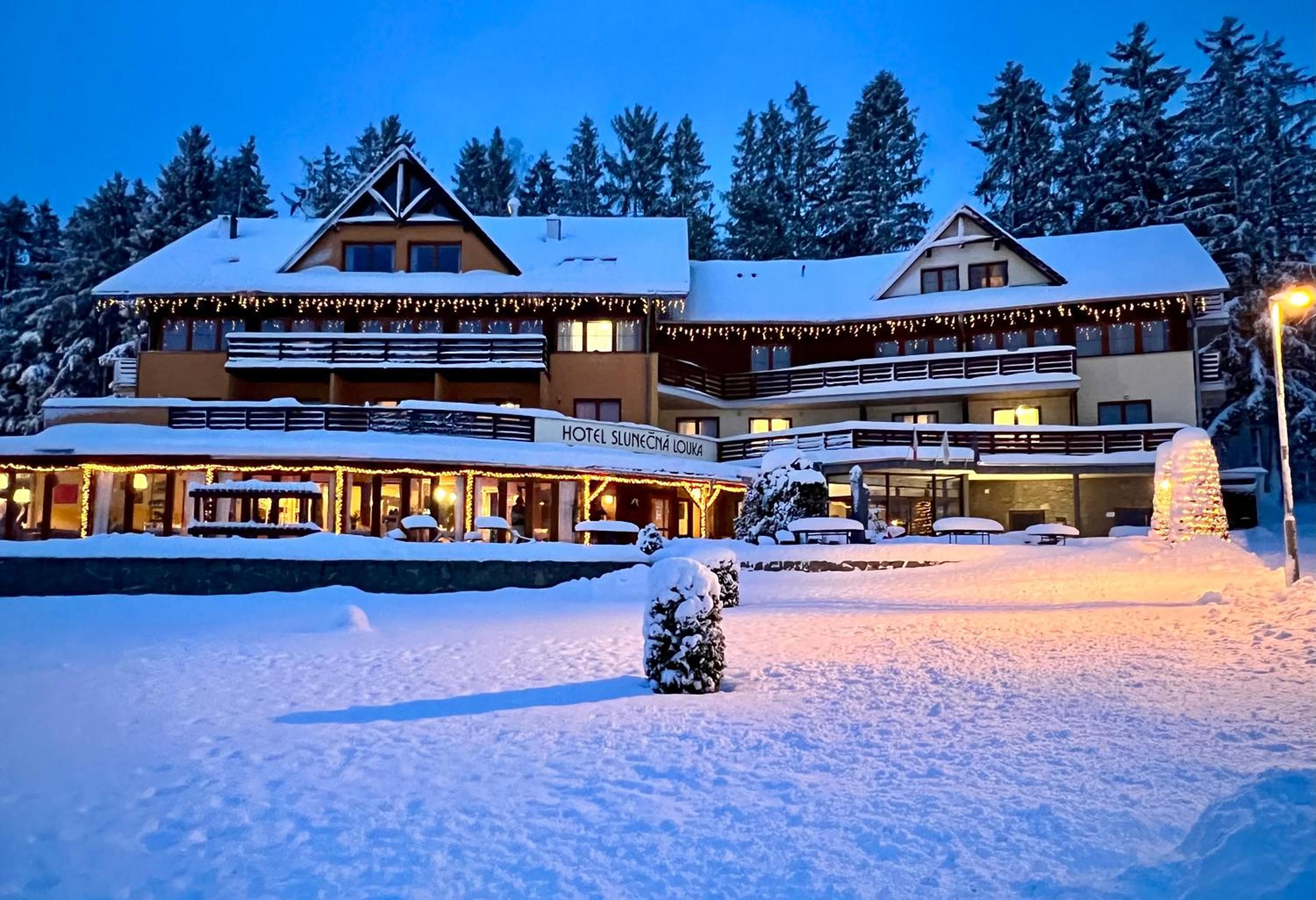 Ein Hotel mit mehreren Etagen, Außenbereich und verschneiter Umgebung.
