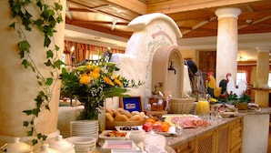 A breakfast buffet with a variety of food items, a coffee station, and a decorative archway. - Landhaus Appartementhaus Haussteiner (Dorfgastein)