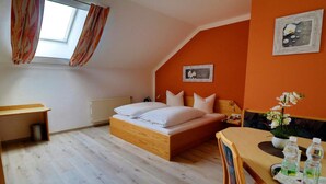 A bedroom with a bed, a desk, and a dining table. - Gasthof Huber (Wels)