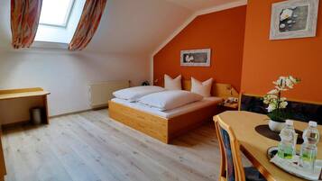 Ein Schlafzimmer mit einem Bett, einem Schreibtisch und einem Esstisch.
