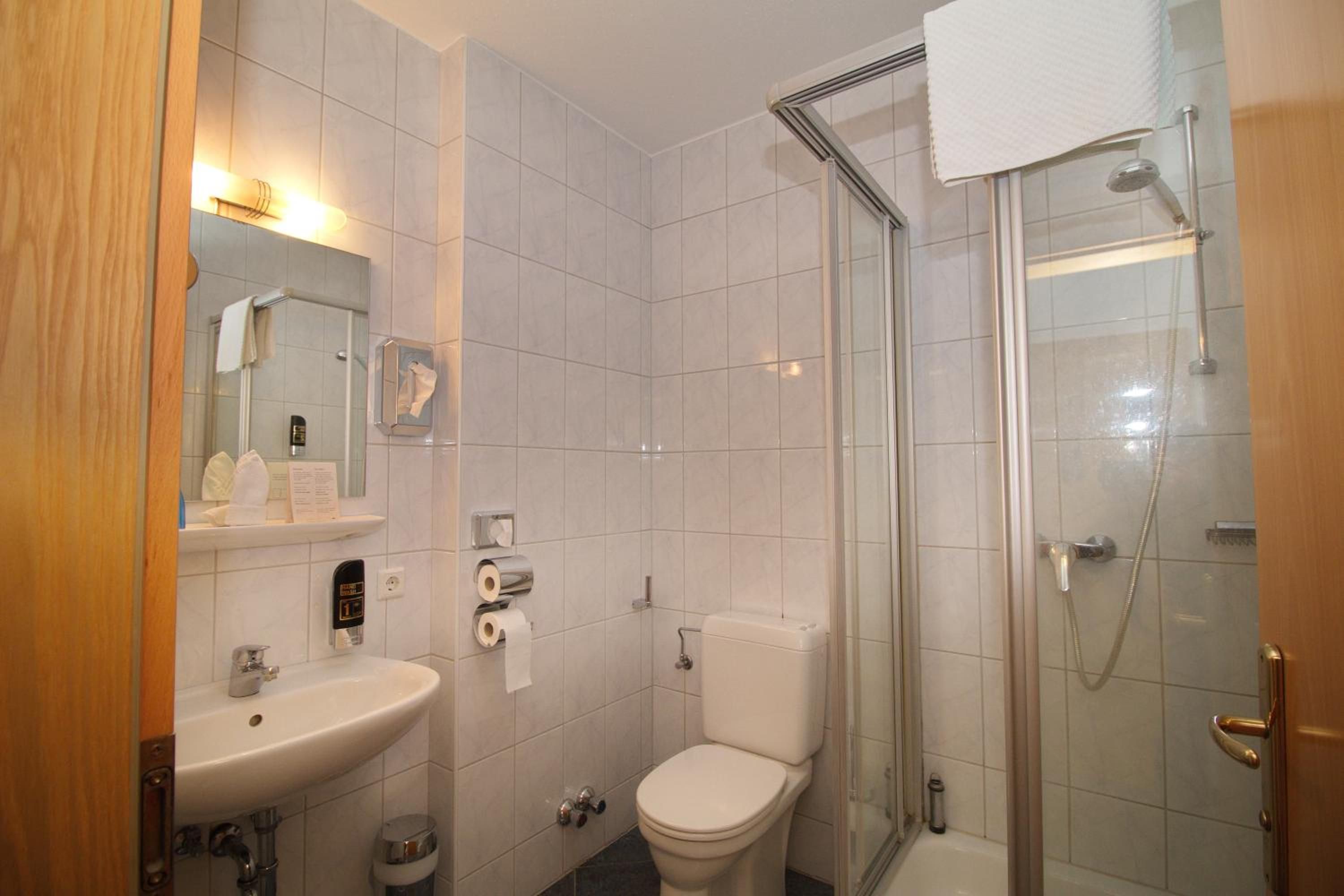 Ein Badezimmer mit Waschbecken, Toilette und einer Duschkabine.