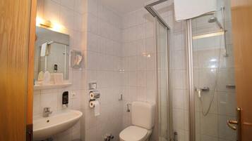 Ein Badezimmer mit Waschbecken, Toilette und einer Duschkabine.
