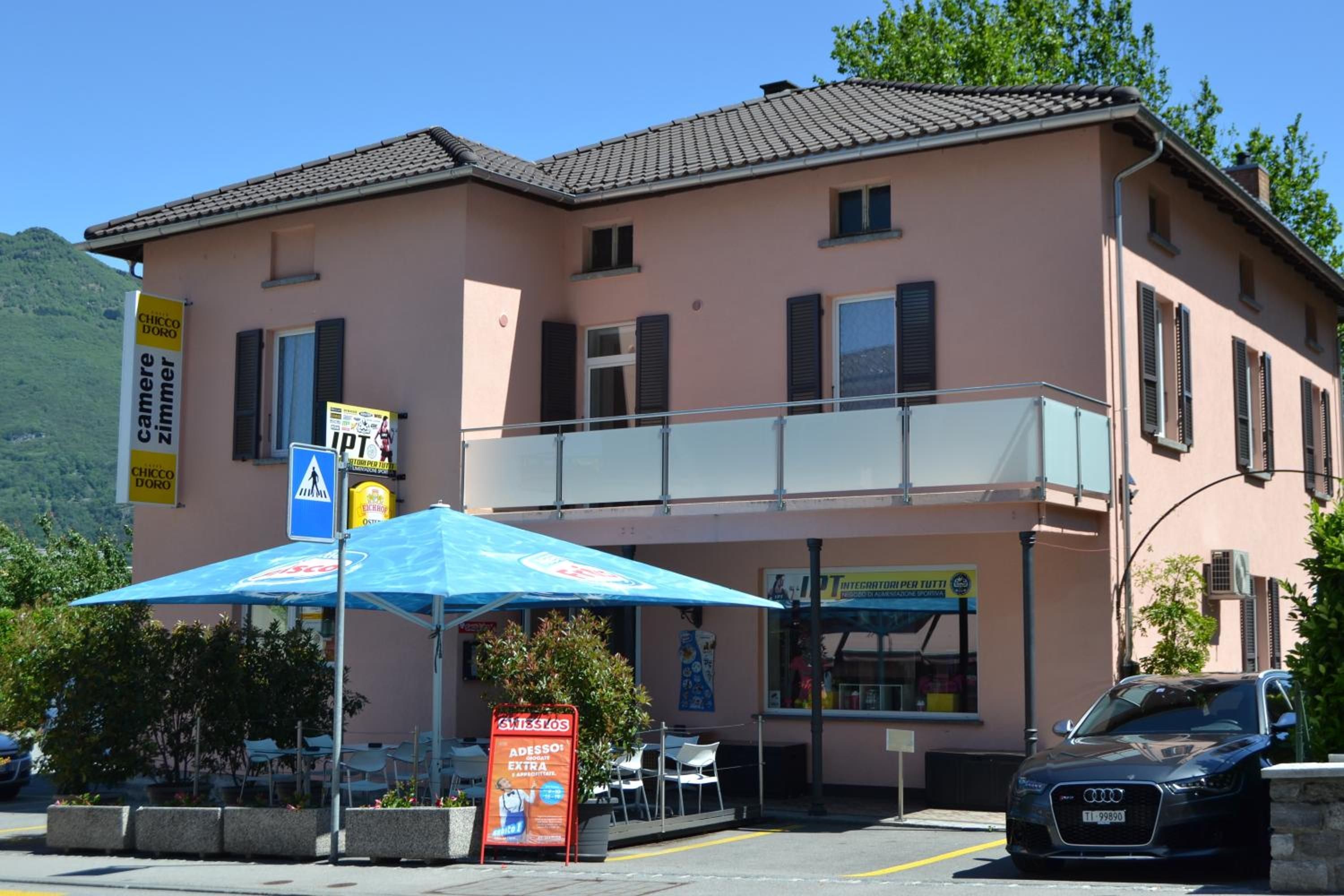 A building with a balcony, outdoor seating, and a sign for a restaurant.