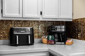 A kitchen with a black toaster, a coffee maker, and a bag of coffee beans. - The Farmhouse | Mountain Views + Room to Roam (Port Angeles East)