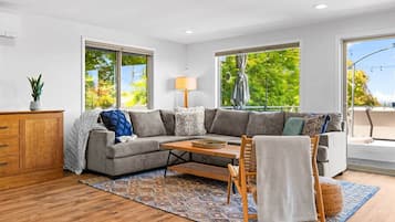 A modern living room with a sectional sofa, a wooden coffee table, and a patterned rug.