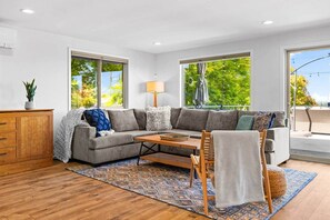 A modern living room with a sectional sofa, a wooden coffee table, and a patterned rug.