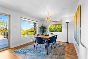 A dining area with a wooden table, blue chairs, and a chandelier.