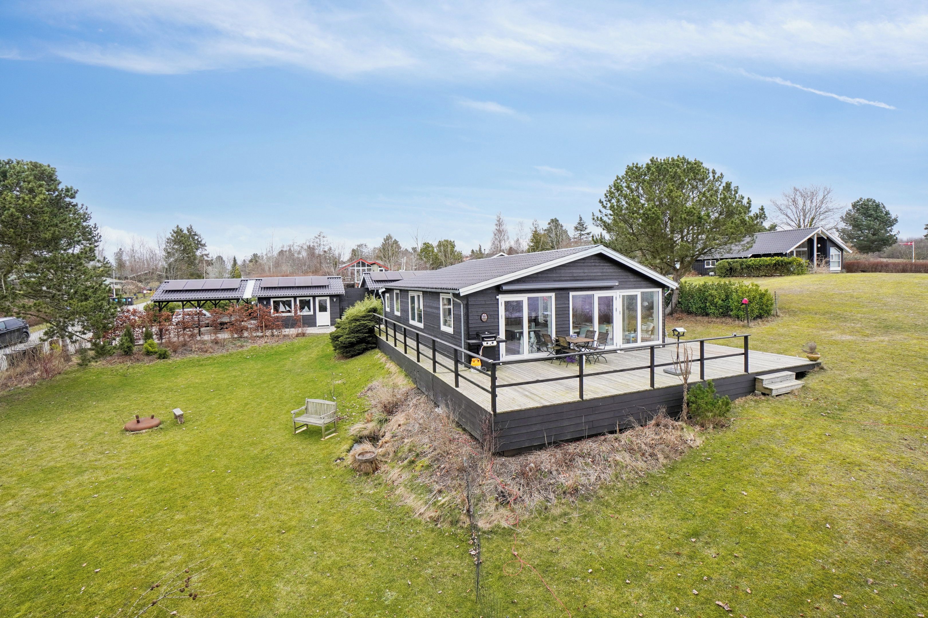 A residential property with a deck, a patio, and a small garden area.