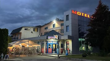 A motel with a prominent sign, a restaurant named 'Formula 1' with a racing theme, and a parking area.