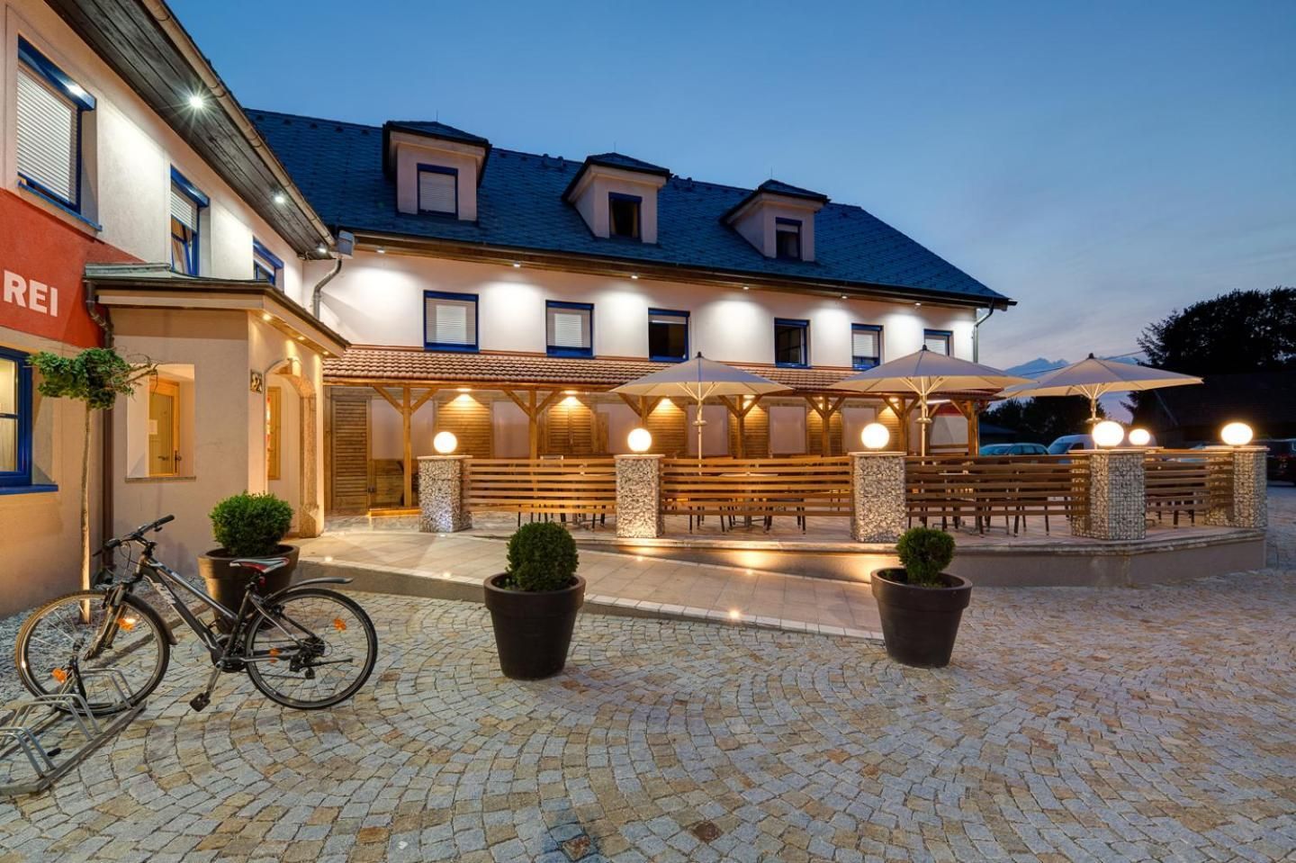 Ein Hotel mit Außenbereich, einem abgestellten Fahrrad und einem Kopfsteinpflasterhof.