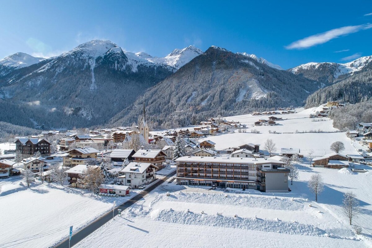 A snow-covered mountain town with buildings and a church.