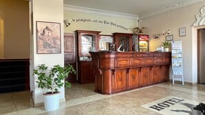 A reception desk with a Coca-Cola machine, a framed picture on the wall, and a sign that says 'HOTEL'. - Hotel Aernvo Orel Oatec (Zatec)