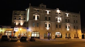 A multi-story building with a classic architectural style, featuring arched windows and a central entrance. - Hotel Aernvo Orel Oatec (Zatec)