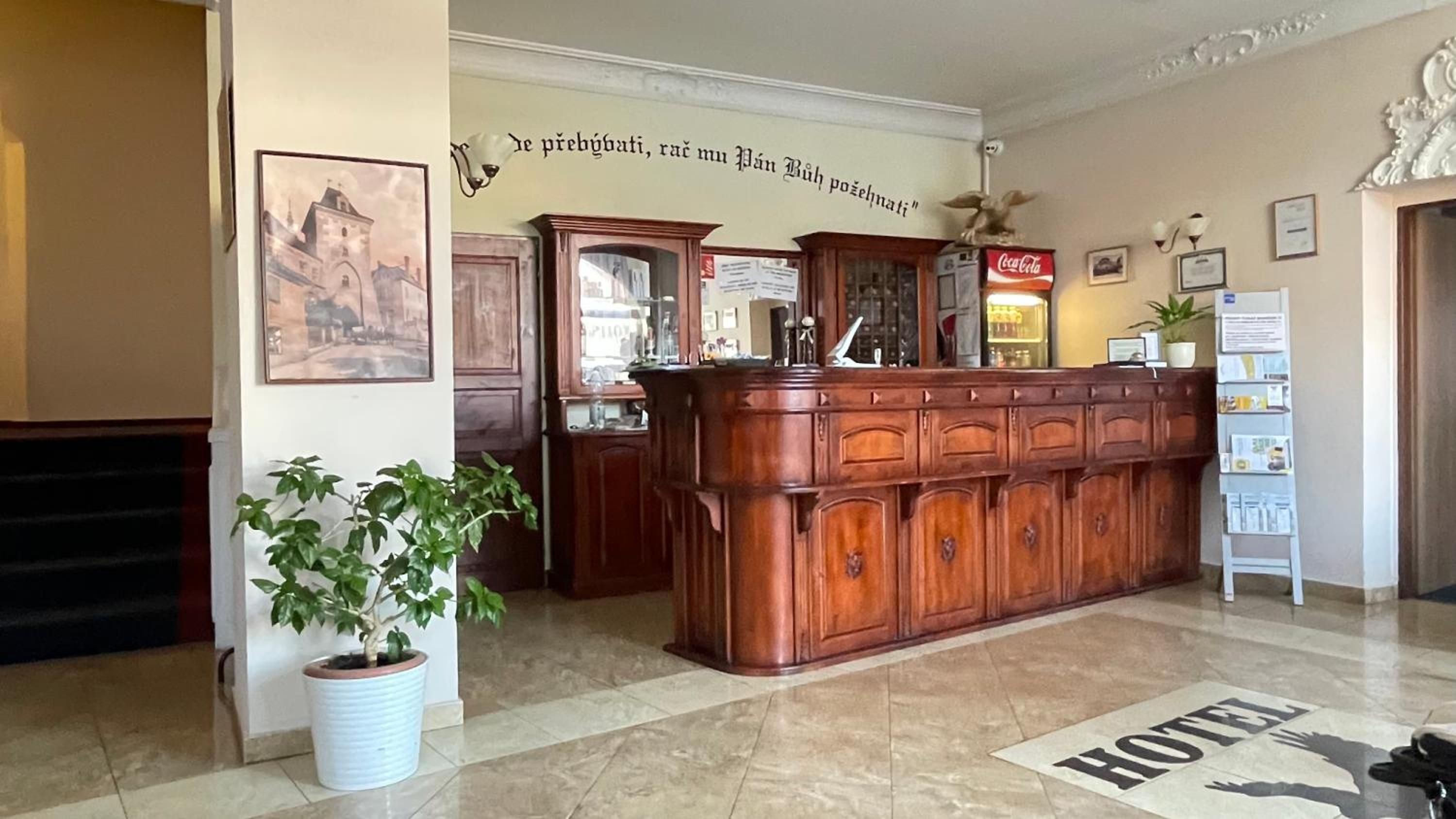 A reception desk with a Coca-Cola machine, a framed picture on the wall, and a sign that says 'HOTEL'.