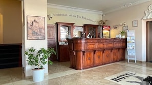 A reception desk with a Coca-Cola machine, a framed picture on the wall, and a sign that says 'HOTEL'.