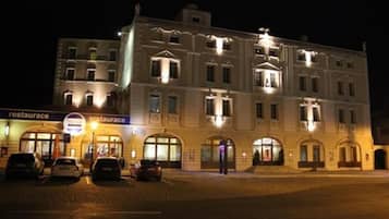 A multi-story building with a classic architectural style, featuring arched windows and a central entrance.